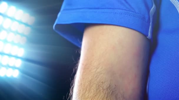 Fußball, Fußballspiel. Fußballprofi im blauen Outfit mit Kapitänsbinde, schwarzer Hintergrund — Stockvideo