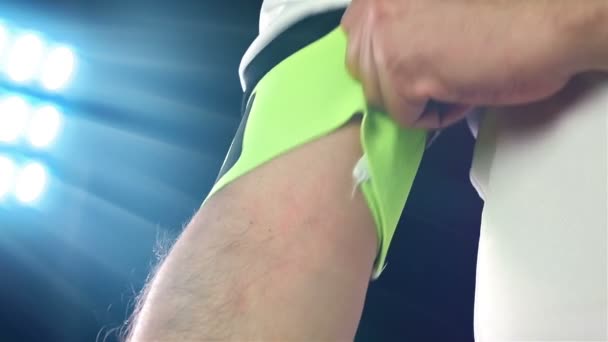 Fußball, Fußballspiel. Fußballprofi im weißen Outfit mit Kapitänsbinde, schwarzer Hintergrund — Stockvideo