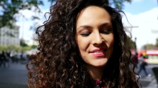 Portrait de jeune femme heureuse avec de beaux cheveux bouclés sirotant du café dans la ville, ralenti — Video