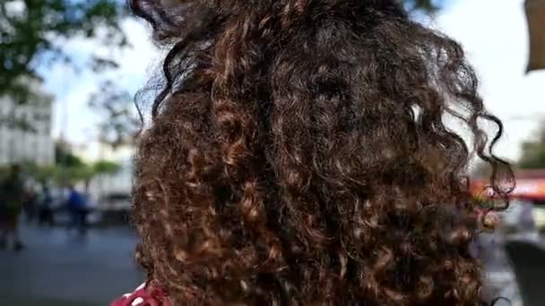 Ritratto di giovane donna felice con bei capelli ricci sorridenti in città, rallentatore — Video Stock