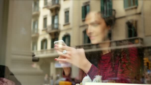 Портрет красивой молодой женщины, использующей смартфон в кафе, замедленная съемка — стоковое видео