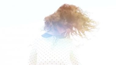 Genç bir kadın beyaz arka planda güzel kıvırcık saçlarını sallıyor, güneş ışığı etkisi, yavaş çekim