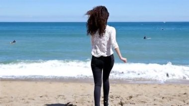 Deniz kıyısında koşan ve yaz güneşinin tadını çıkaran genç kadının yavaş hareketi