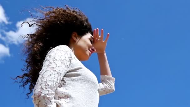 Χαμηλή γωνία βολή ευτυχισμένη νεαρή γυναίκα απολαμβάνοντας τον καλοκαιρινό ήλιο στο γαλάζιο του ουρανού, αργή κίνηση — Αρχείο Βίντεο