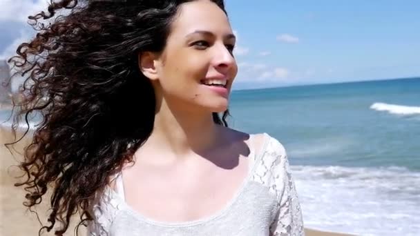 Retrato de jovem feliz com belos cabelos encaracolados na costa do mar, câmera lenta — Vídeo de Stock