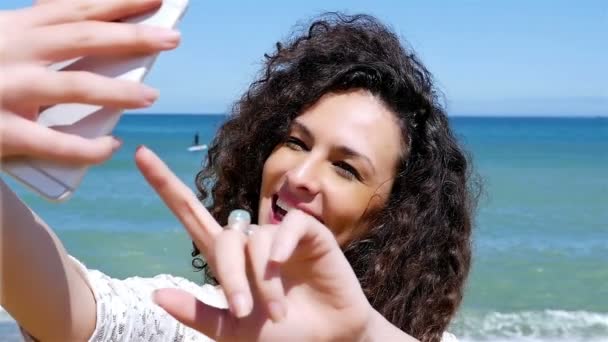 Portrait de jolie jeune femme prenant selfie avec un téléphone intelligent sur la plage, au ralenti — Video