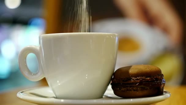 Tazza di caffè con macaron marrone in un caffè al coperto — Video Stock