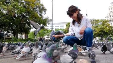 Placa de Catalunya, Barcelona, ağır çekimde sürü Güvercin besleyen kadın