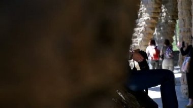 Fotoğraf ve turistler Antoni Gaudi's Park Guell, Barselona'da sütunlu bir patikada