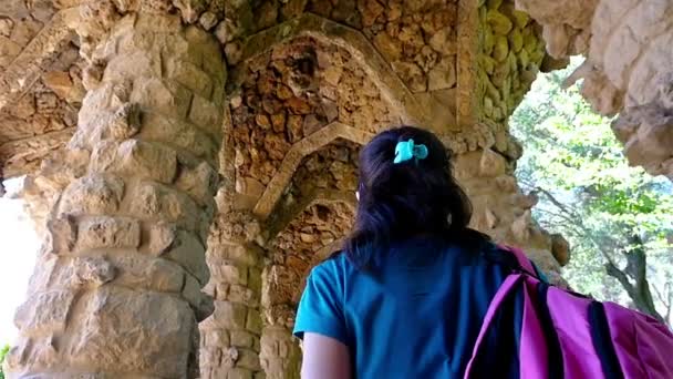 안토니 가우디의 공원 Guell, 바르셀로나에서 식민지 보도의 아치를 존경 하는 관광 여성 — 비디오