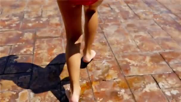 Ragazzina che salta su una piscina, tracciando la telecamera sulle gambe — Video Stock