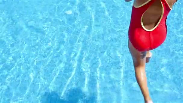 Slow motion van een klein meisje in een zwembad springen — Stockvideo