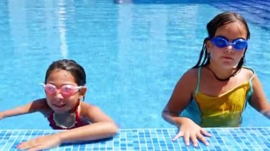 İki küçük kız bir havuzdan gelen mayo