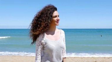 Genç kadın güzel kıvırcık saçlı el takip ile beni ve plajda çalışan