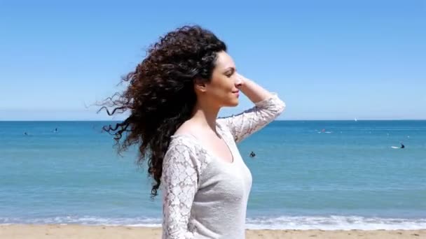 Retrato de una joven feliz con hermoso cabello rizado disfrutando del sol de verano en la orilla del mar — Vídeos de Stock