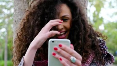 Genç ve güzel kadın selfie bir akıllı telefon ile parkta alarak portresi