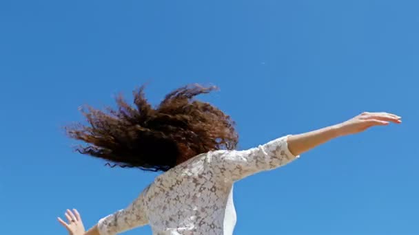 Låg vinkel skott av ung kvinna med utsträckta armar du njuter av sommarsolen på blå himmel — Stockvideo