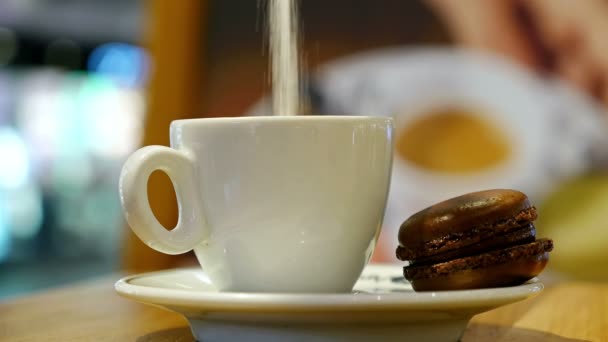 Taza de café con macaron marrón en un café de interior — Vídeo de stock