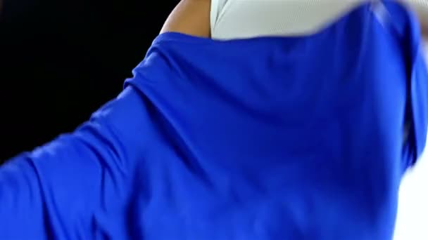 Mavi T-shirt siyah arka plan üzerine koyarak futbolcu — Stok video