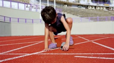 Küçük çocuk atletik bir parça çalıştırılmaya hazırlanıyor