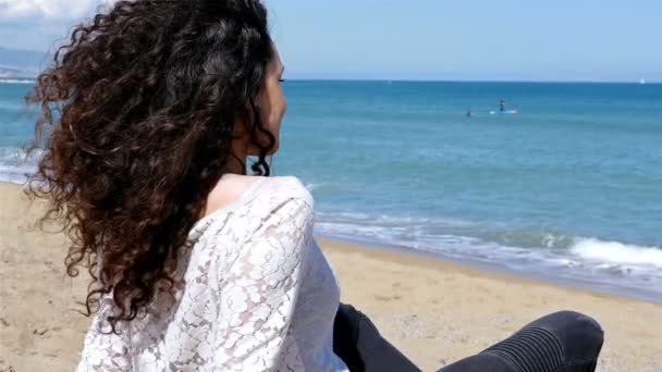 Mujer joven feliz con hermoso pelo rizado disfrutando del sol de verano en la orilla del mar — Vídeo de stock