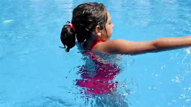 Carina bambina che balla nell'acqua di una piscina — Video Stock