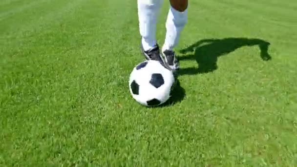 Voetballer leidt de bal op een voetbalveld — Stockvideo