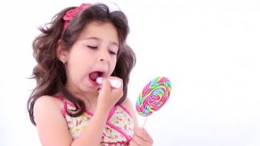 Küçük kız bir ruj koyarak bir lolipop bir ayna kullanarak