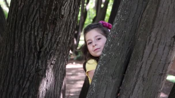 Kız ağacın arkasına saklanıyor. — Stok video