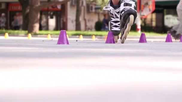 男女用溜冰鞋和滑板车在一排圆锥之间织造 — 图库视频影像