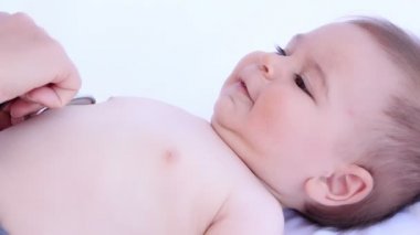 Çocuk Doktor mutlu bebek çocuk beyaz bir arka plan üzerinde stetoskop ile incelenmesi