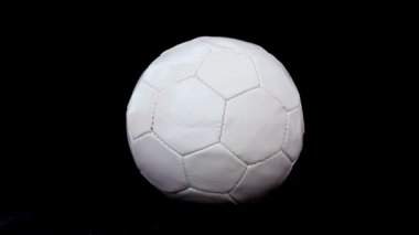 Futbol topu siyah bir arka plan üzerinde dönmeye, yakın çekim