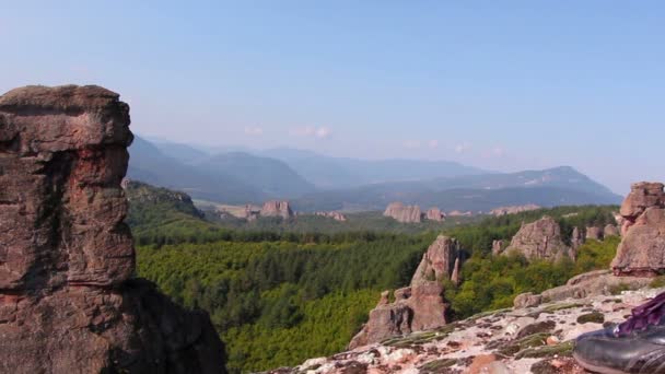 Women feet in sport shoes step on a rock, tourist admire the Belogradchik valley — Stock Video