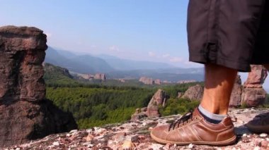 Erkek spor ayakkabı adım bir kayaya ayaklarda, turist hayran Belogradchik Vadisi