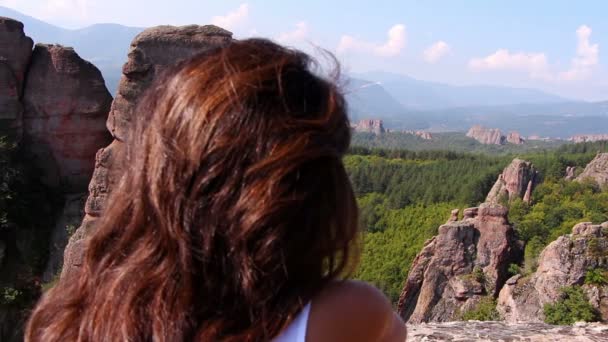 Kayanın üzerinde oturan ve güzel Belogradchik Vadisi hayran kadın — Stok video