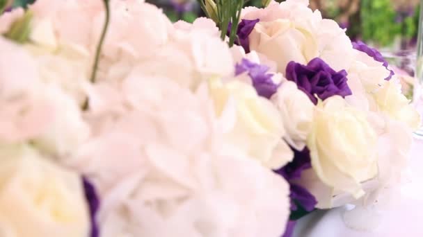 Decoración de la boda con flores y velas blancas y moradas — Vídeo de stock