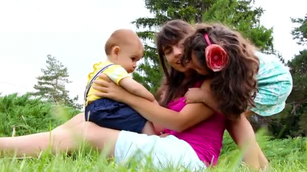 Madre, hija e hijo pequeño jugando juntos en la hierba — Vídeos de Stock