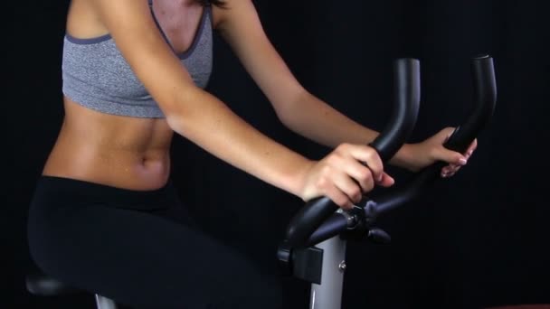 Close up of a young woman riding stationary bike — Stock Video