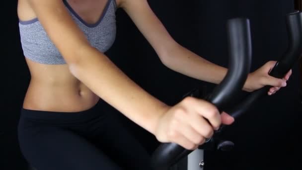 Close up of a young woman riding stationary bike — Stock Video