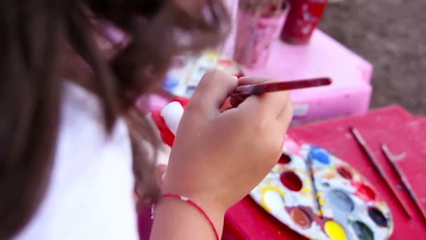 Joven pintura sobre una figura de cerámica — Vídeo de stock