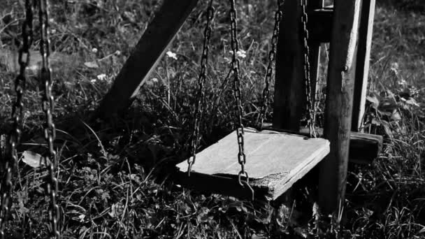 Black and white video of empty broken swing, concept of abandoned child — Stock Video