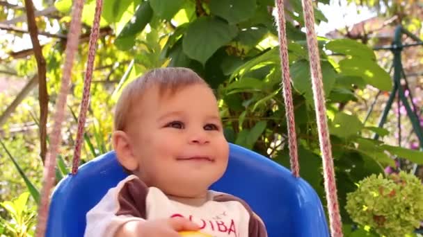 귀여운 작은 아기는 정원에서 스윙 — 비디오