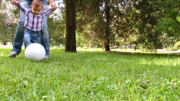 Bonito menino brincando com bola de futebol apoiado por sua mãe — Vídeo de Stock