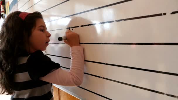 Mädchen schreibt mathematische Ausdrücke an die Tafel in einem Klassenzimmer — Stockvideo