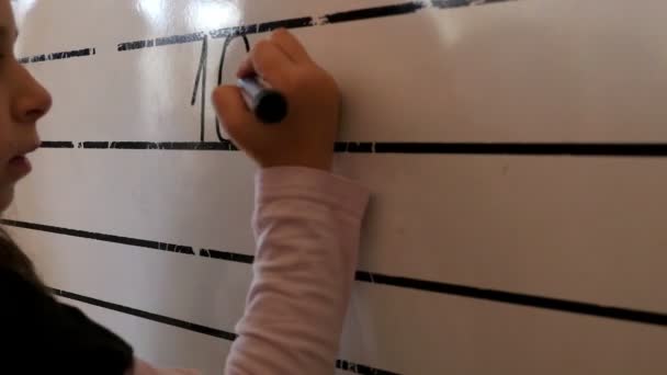 Girl writing mathematic expression on the blackboard in a classroom — Stock Video