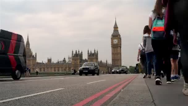 Проміжок часу, автобуси, Легкові автомобілі та пішоходів, що переходять Вестмінстерський міст з Біг-Бена та будівлі парламенту у фоновому режимі — стокове відео