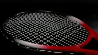 Üç yeni tenis topları kümesi tenis raketi üzerinde siyah arka plan üzerine koyarak el