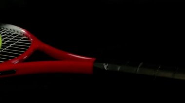 Tenis raketi üç tenis topları ile üzerine siyah bir zemin üzerine, dolly