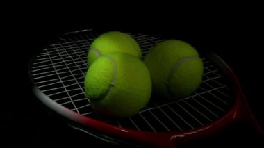 Siyah arka plan üzerine ışık süpürme etkisi üzerinde bir tenis raketi üç tenis topları ile