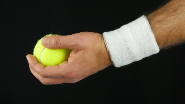 Gros plan de la main d'un joueur de tennis prêt à lancer la balle de tennis avant de la frapper, fond noir — Video